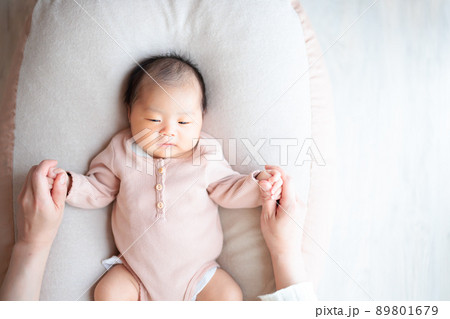 ねんね期 スキンシップをとる赤ちゃんとママ まだ無表情の写真素材