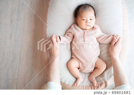 ねんね期 スキンシップをとる赤ちゃんとママの写真素材