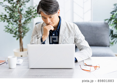 ソファのある明るい部屋でデスクワークをしているビジネスマン 89801883
