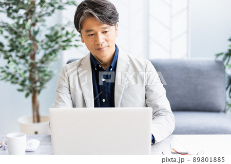 ソファのある明るい部屋でデスクワークをしているビジネスマン ソファのある明るい部屋でデスクワークをしているビジネスマン 89801885