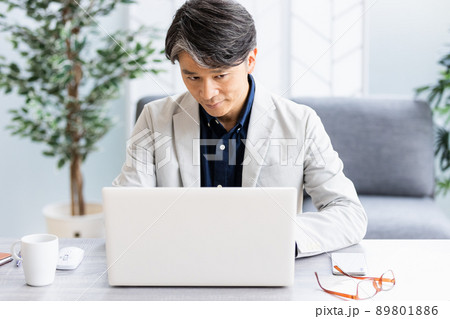 ソファのある明るい部屋でデスクワークをしているビジネスマン 89801886