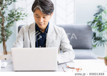 ソファのある明るい部屋でデスクワークをしているビジネスマン ソファのある明るい部屋でデスクワークをしているビジネスマン 89801888
