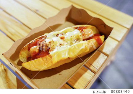 hotdog in the paper plate on the wooden table in foodtruck, food street event, Thailand. 89803449