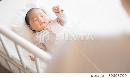 女性の肩越しの赤ちゃん　お母さん　産後の来客　おばあちゃん　友人　 89803709