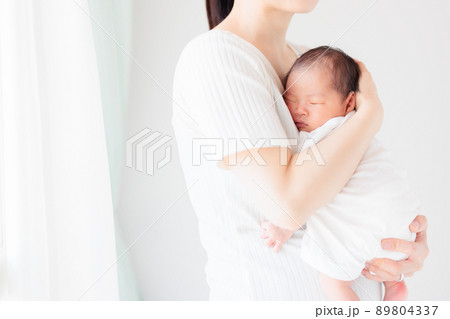 新生児の赤ちゃんを抱っこ　縦抱き　コピースペース 89804337