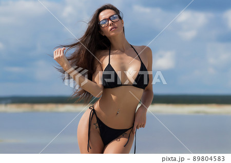 Beautiful woman in swimsuit on beach Beautiful woman in swimsuit on beach 89804583
