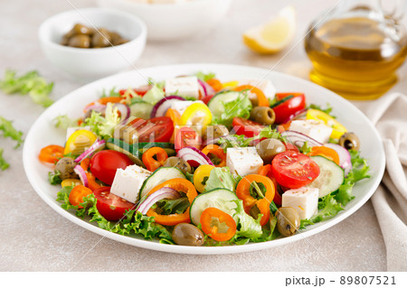 Greek salad with feta cheese, tomatoes, cucumbers, pepper, red onion and green olives. Top view Greek salad with feta cheese, tomatoes, cucumbers, pepper, red onion and green olives. Top view 89807521
