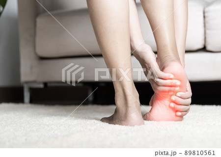 Asian woman standing feeling pain in her foot at home 89810561