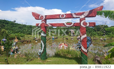 ≪石垣島≫ 赤と緑の鳥居と池にあるたくさんのシーサーの写真素材