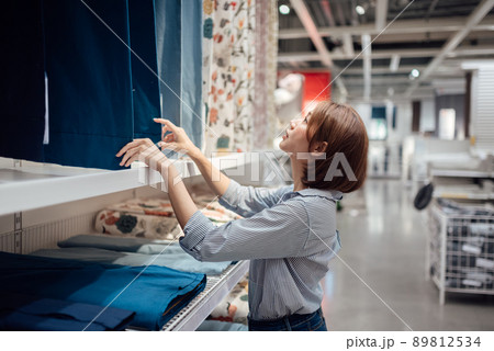 An Asian woman is selecting fabric and textile at the mall. 89812534