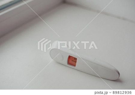 Non-contact thermometer on a white background for measuring body temperature 89812936
