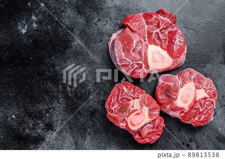 Fresh veal meat osso buco shank steak, italian ossobuco. Black background. Top view. Copy space Fresh veal meat osso buco shank steak, italian ossobuco. Black background. Top view. Copy space 89813538