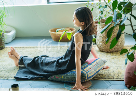 観葉植物に囲まれてリラックスする女性  89813610
