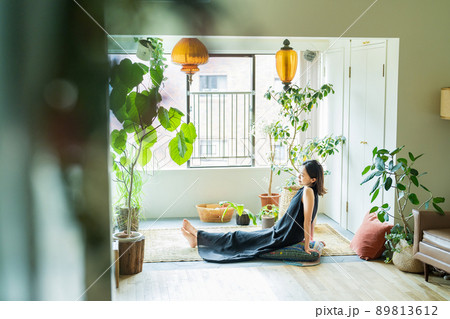 観葉植物に囲まれてリラックスする女性  89813612