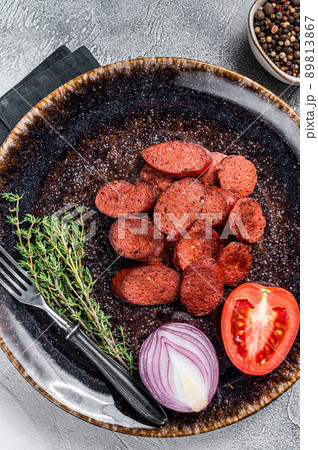 Fried sausage sucuk from beef meat on a plate with herbs. White background. Top view 89813867