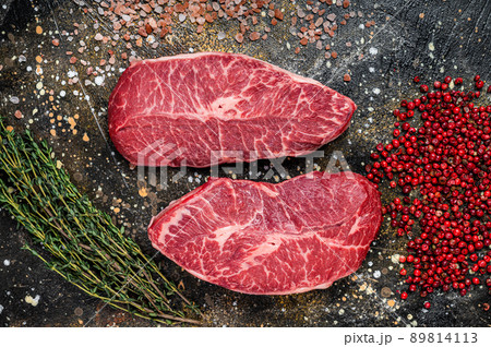 Raw Shoulder Top Blade cuts, beef meat steaks. Brown background. Top View 89814113
