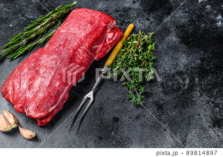 Raw fillet Tenderloin beef meat for steaks with thyme and rosemary. Black background. Top view. Copy space 89814897