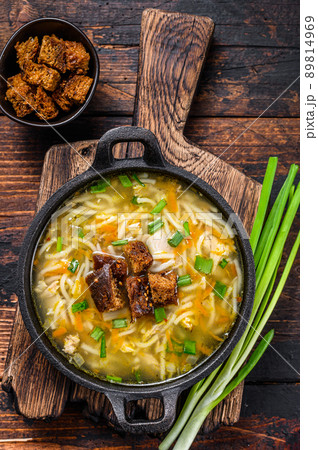 Chicken soup with noodles and vegetables. Dark wooden background. Top view 89814969