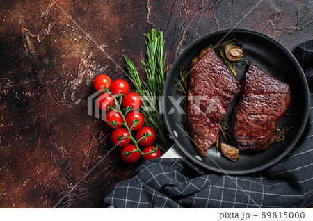 Grilled denver beef meat steak in a pan with rosemary. Dark background. Top view. Copy space 89815000