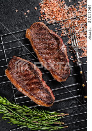 BBQ Grilled cap rump or Top sirloin beef steak, fried meat on grill. Black background. Top view 89815066