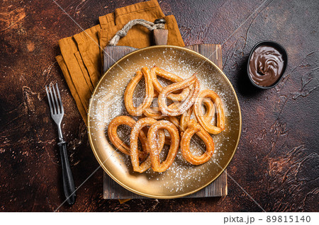 Spanish dessert churros with hot spicy chocolate. Dark background. Top view Spanish dessert churros with hot spicy chocolate. Dark background. Top view 89815140
