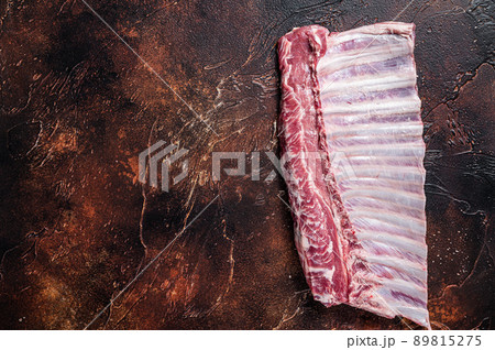 Raw rack of lamb ribs on butcher table. Dark background. Top view. Copy space Raw rack of lamb ribs on butcher table. Dark background. Top view. Copy space 89815275