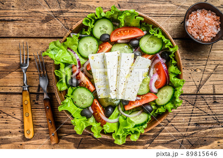 Greek salad with fresh vegetables and feta cheese. Wooden background. Top view Greek salad with fresh vegetables and feta cheese. Wooden background. Top view 89815646