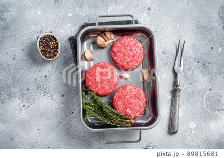 Fresh Raw Ground mince beef meat Hamburger steak patty in a steel tray. Gray background. Top view Fresh Raw Ground mince beef meat Hamburger steak patty in a steel tray. Gray background. Top view 89815681