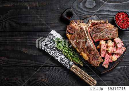 Sliced and roast T-bone or porterhouse beef meat Steak for steakhouse menu. Black wooden background. Top view. Copy space Sliced and roast T-bone or porterhouse beef meat Steak for steakhouse menu. Black wooden background. Top view. Copy space 89815753