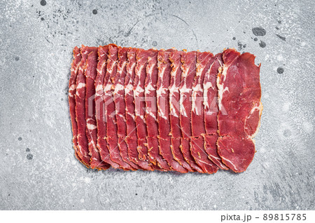 Turkish bacon Pastrami beef meat. Gray background. Top view Turkish bacon Pastrami beef meat. Gray background. Top view 89815785