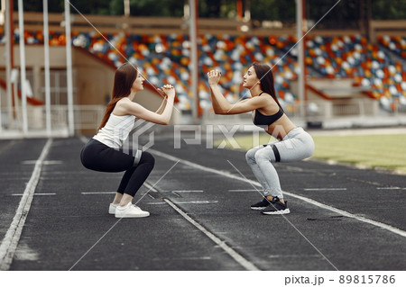 Beautiful girls at the stadium. Sports girls in a sportswear. People use a eraser. 89815786