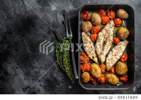 Roasted halibut fish steaks with tomato and potato. Black background. Top view. Copy space Roasted halibut fish steaks with tomato and potato. Black background. Top view. Copy space 89815889