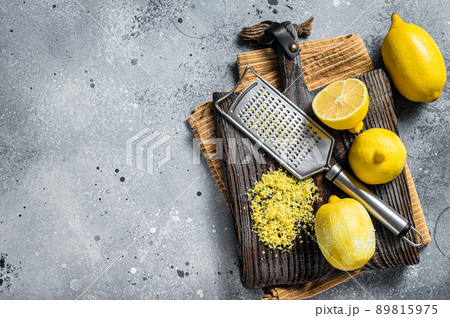 Raw grated Lemon Zest peel on wooden board. Gray background. Top view. Copy space Raw grated Lemon Zest peel on wooden board. Gray background. Top view. Copy space 89815975