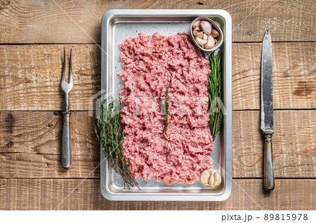 Turkey or chicken mince raw meat in a kitchen tray. Wooden background. Top View Turkey or chicken mince raw meat in a kitchen tray. Wooden background. Top View 89815978