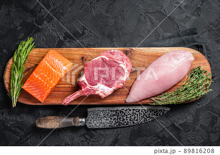 Raw meat steaks - fish salmon, beef veal and turkey. Black background. Top view Raw meat steaks - fish salmon, beef veal and turkey. Black background. Top view 89816208