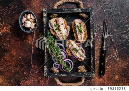 Tapas with sardine and sprat, cream cheese and onion. Dark background. Top view 89816238
