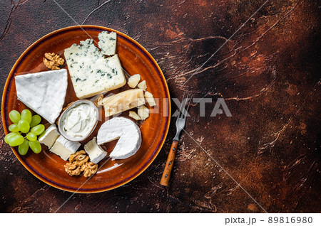 Cheese plate with Brie, Camembert, Roquefort, blue cream cheese, grape and nuts. Dark background. Top view. Copy space Cheese plate with Brie, Camembert, Roquefort, blue cream cheese, grape and nuts. Dark background. Top view. Copy space 89816980