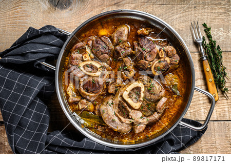 Stewed veal shank meat Osso Buco, italian ossobuco steak. wooden background. Top view Stewed veal shank meat Osso Buco, italian ossobuco steak. wooden background. Top view 89817171