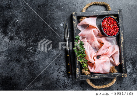 Thin sliced Smoked pork ham in wooden tray. Black background. Top view. Copy space 89817238