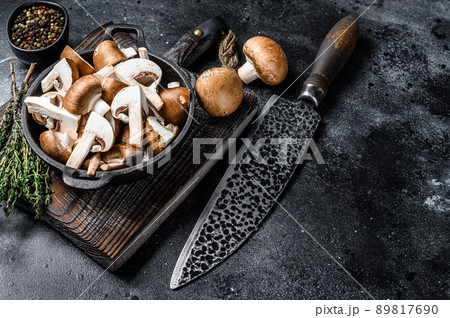 Sliced Raw mushrooms brown champignon. Black background. Top view. Copy space 89817690