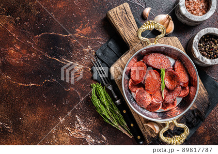 Turkish fried sausage sucuk in a pan. Dark background. Top view. Copy space 89817787