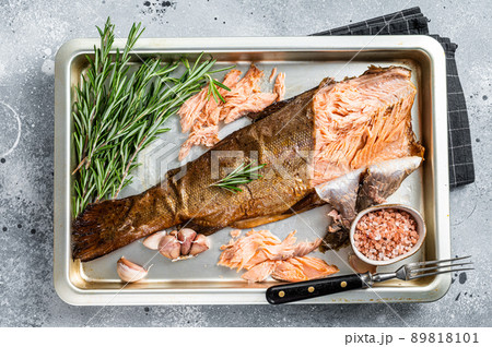 Hot smoked salmon, trout fish with herbs. Gray background. Top view 89818101
