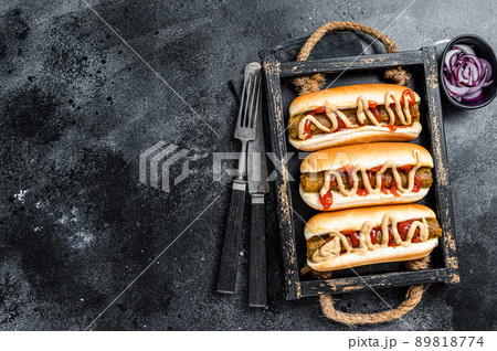 Vegan hot-dog with with assorted toppings and meatless Vegetarian sausage. Black background. Top view. Copy space Vegan hot-dog with with assorted toppings and meatless Vegetarian sausage. Black background. Top view. Copy space 89818774