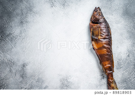 Hot smoked whole fish on kitchen table. White background. Top view. Copy space 89818903