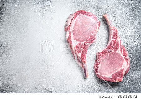 Raw dry aged tomahawk pork chop steak. White background. Top view. Copy space 89818972