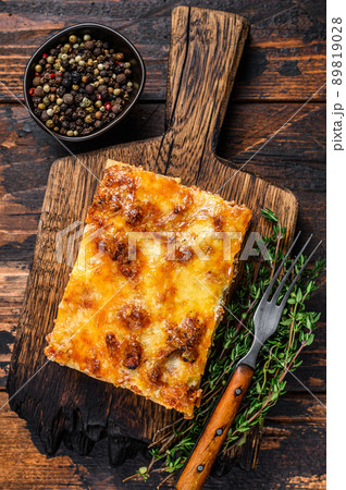 Italian Lasagna with bolognese sauce and mince beef meat. Dark Wooden background. Top view Italian Lasagna with bolognese sauce and mince beef meat. Dark Wooden background. Top view 89819028