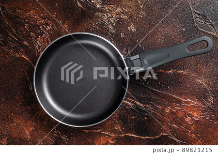Empty iron frying pan on rustic table. Dark background. Top view. Copy space 89821215