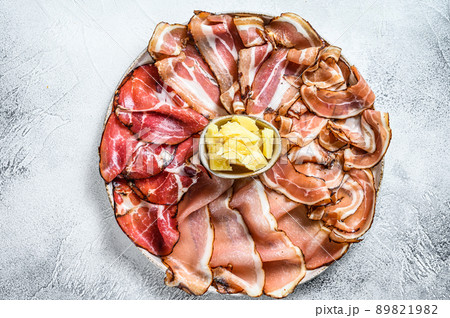 Meat antipasto platter, pancetta, salami, sliced ham, sausage, prosciutto, bacon. Gray background. Top view Meat antipasto platter, pancetta, salami, sliced ham, sausage, prosciutto, bacon. Gray background. Top view 89821982