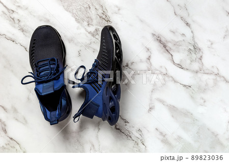 Laced up grooved men shoes on a marble floor. Laced up grooved men shoes on a marble floor. 89823036