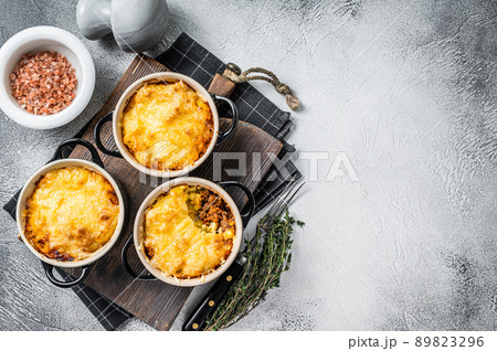 British dish Shepherd's pie with ground meat, mashed potato and cheddar cheese crust. White background. Top view. Copy space British dish Shepherd's pie with ground meat, mashed potato and cheddar cheese crust. White background. Top view. Copy space 89823296
